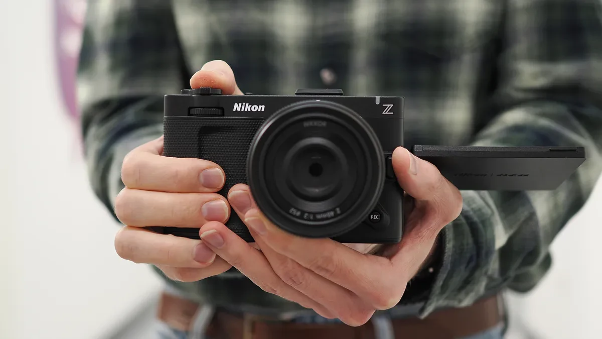 Mike Harris holding a Nikon ZR with 40mm lens in an office building