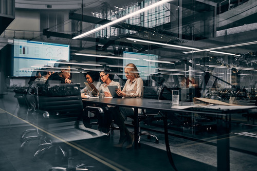 Modern business. Young focused serious business women and men working in a conference room working o.jpg