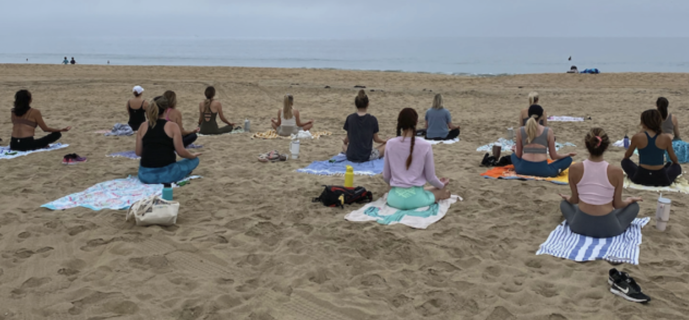 Newport Peach community practicing a calm seated beach session