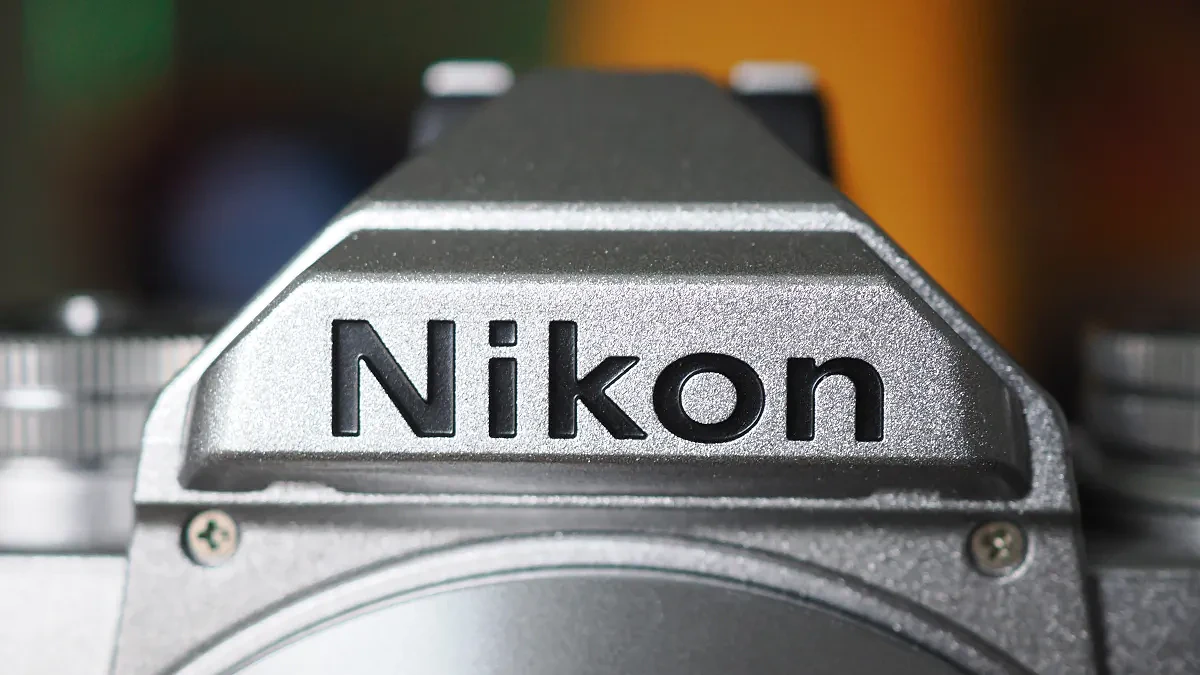 Close-up of the Nikon logo on a silver Nikon Zfc camera