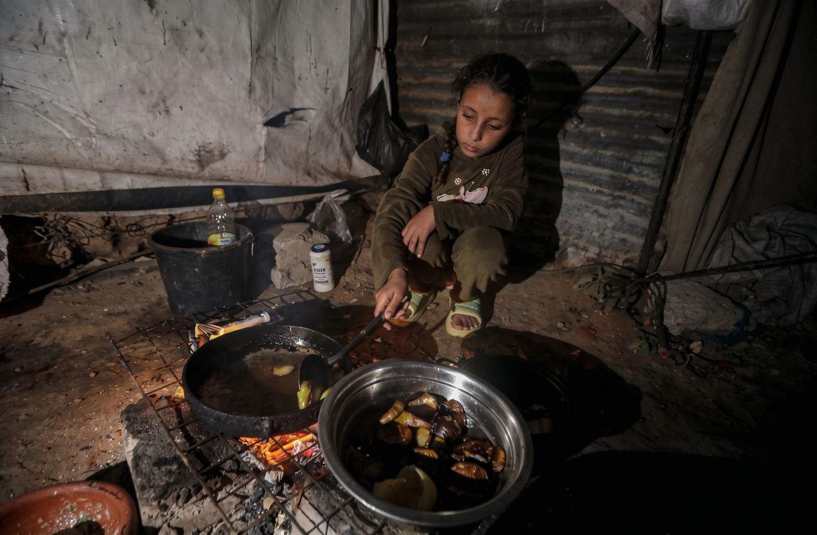 Hayam preparing food in her family's tent in Gaza