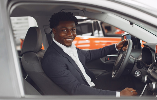 Handsome and elegant black man in a car salon.jpg