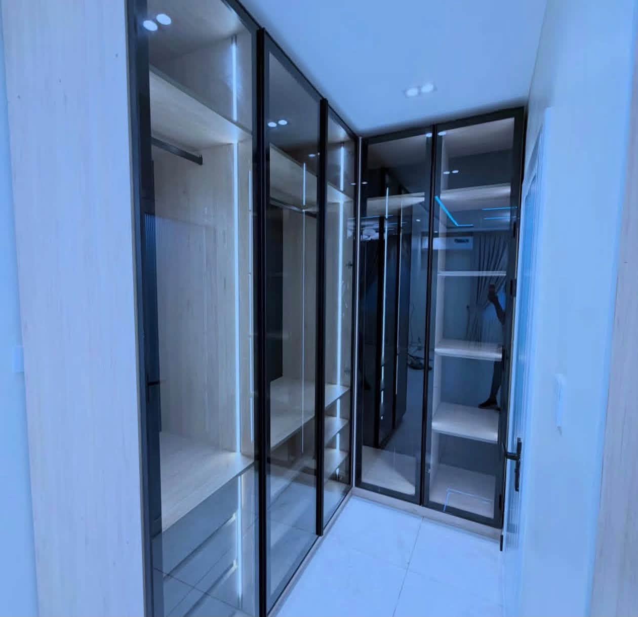 Luxury Contemporary Residential Estate - Custom walk-in wardrobe with smoked glass doors and vertical LED illumination