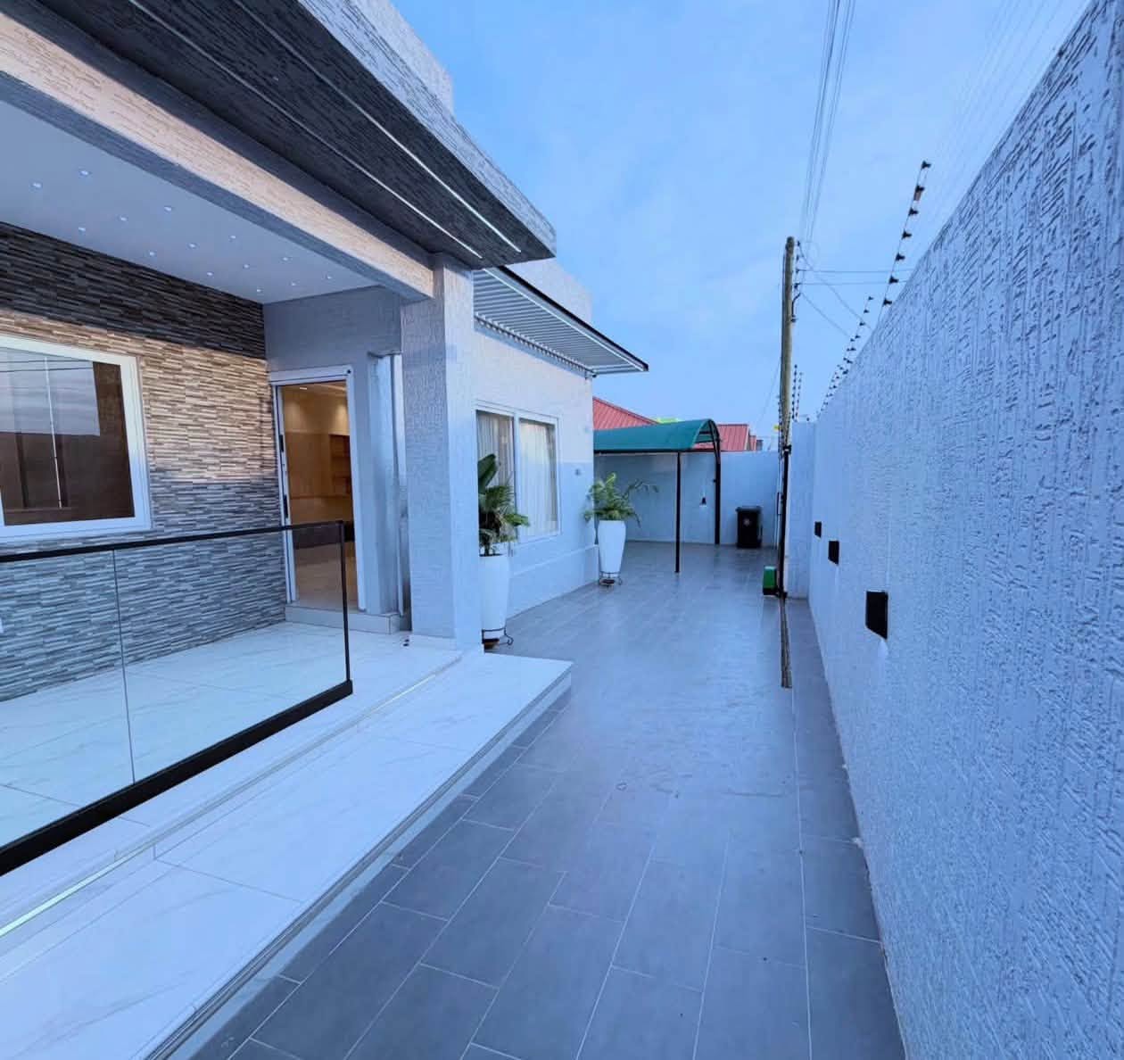 Luxury Contemporary Residential Estate - Side walkway with textured exterior walls, glass railings, and security fixtures
