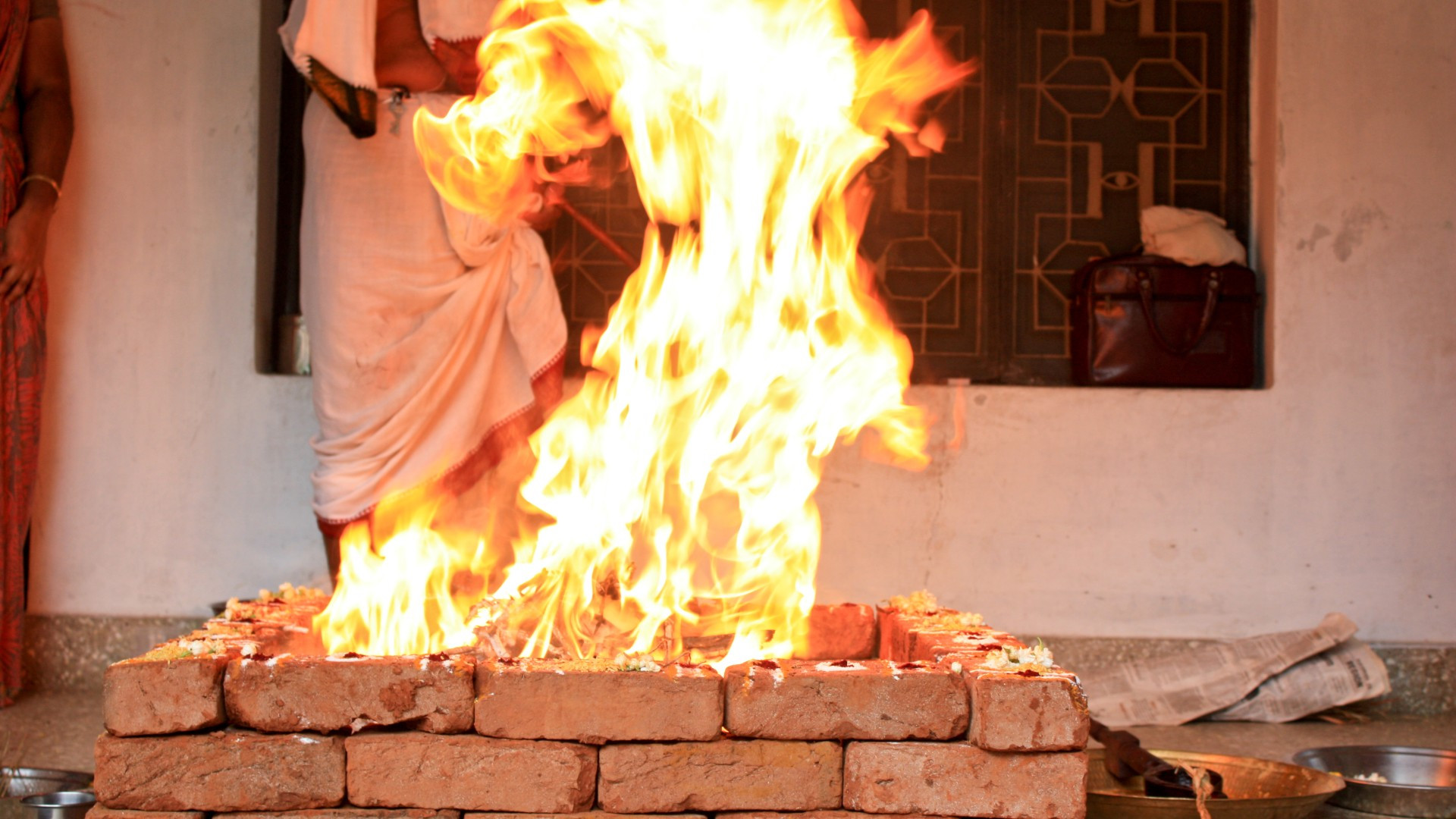 वैदिक यज्ञ एवं गायत्री हवन — प्रज्वलित अग्नि वेदी में गायत्री मंत्र की पावन आहुतियां देते ऋत्विज