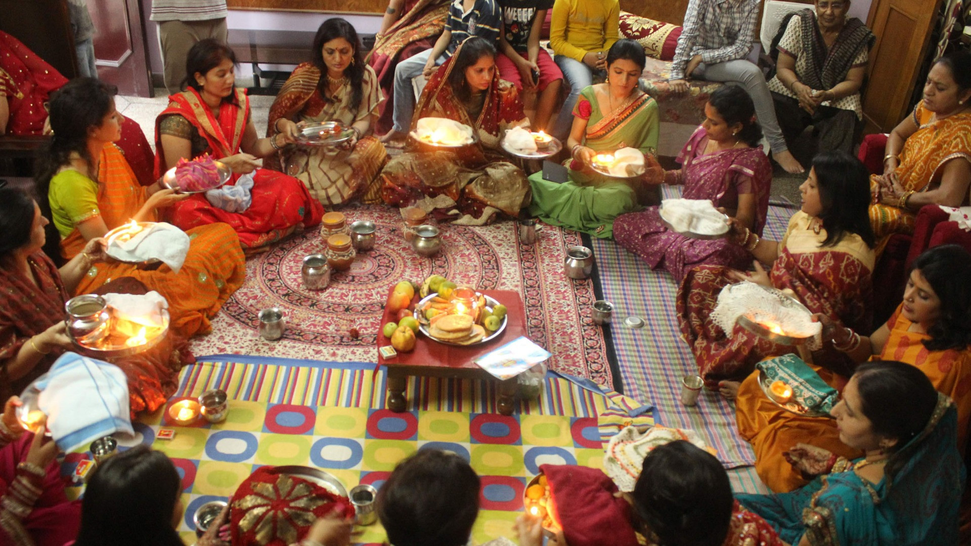 करवा चौथ सामूहिक पूजा — पारंपरिक वेशभूषा में एकत्रित होकर कथा श्रवण और करवा फेरती सुहागिनें
