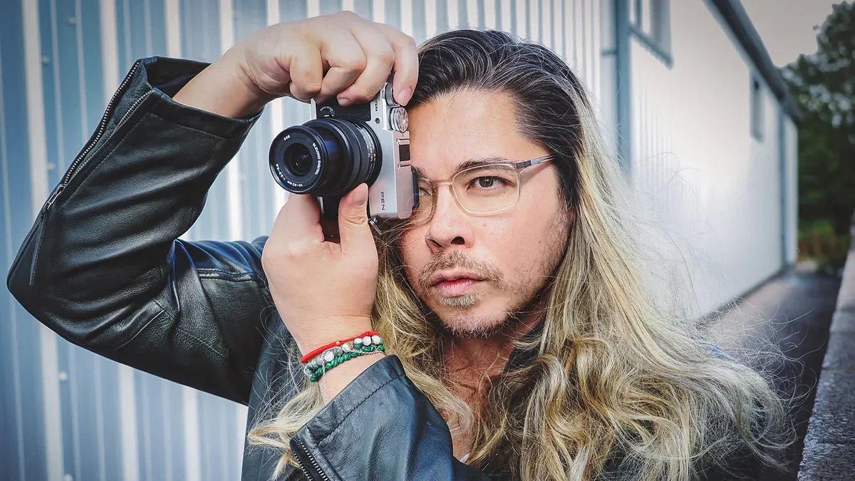James Artaius taking a photograph with the OM System PEN in an urban environment