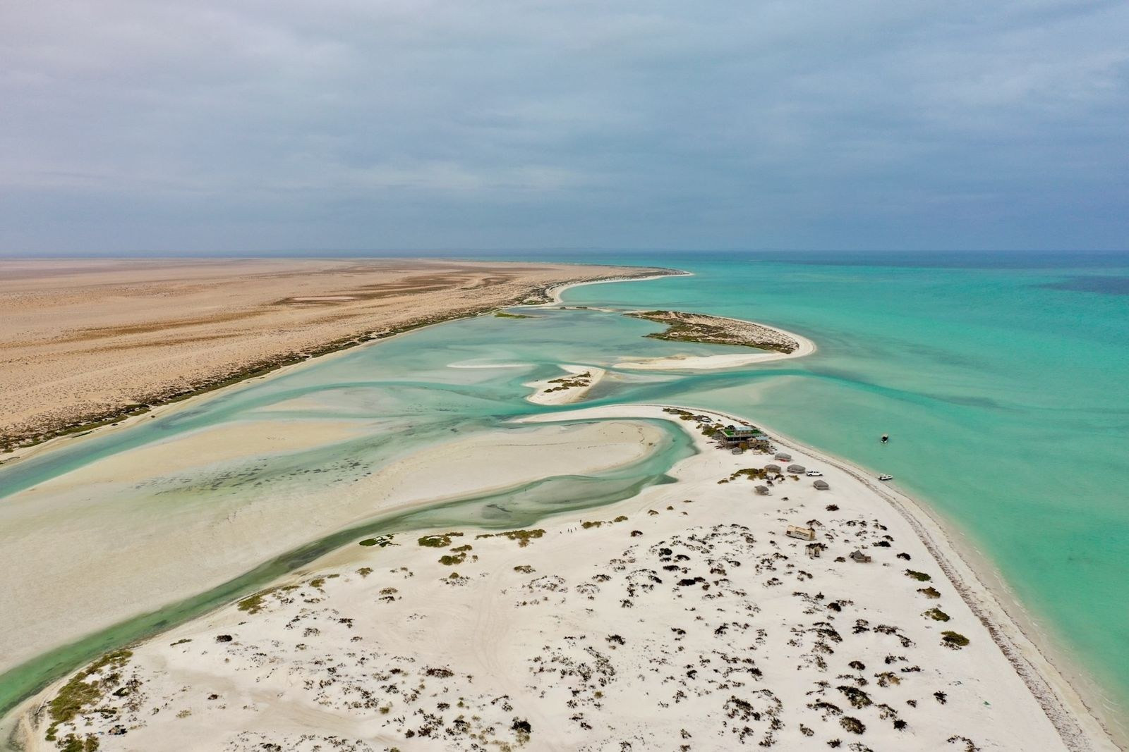 Aerial view of turquoise water and white sand along the Omani coast