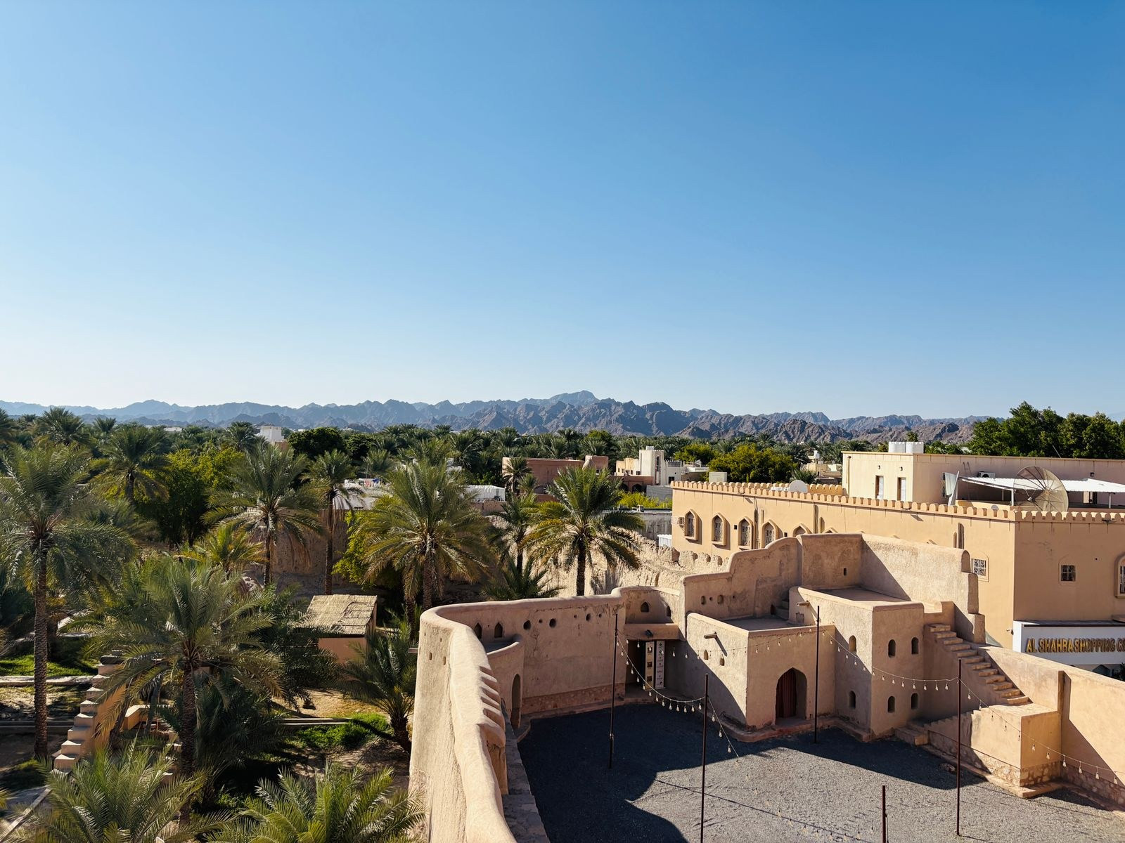 Nizwa Fort and palm oasis with the Hajar Mountains in the background