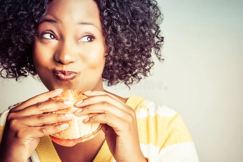 satisfied 06 attractive black woman looking very content eating a big burger aka gloating happiness .png