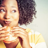 satisfied 06 attractive black woman looking very content eating a big burger aka gloating happiness 