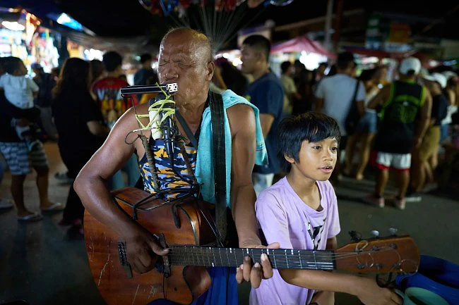 A blind man is busking during the Ati Atihan festival in Kalibo.