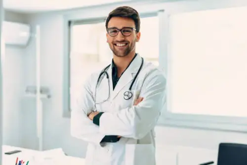 handsome male doctor with stethoscope over neck working while looking at camera in the.webp