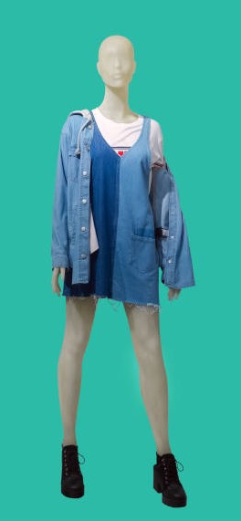 Full length female mannequin dressed in jeans jacket and sundress, isolated on green background. No .jpg