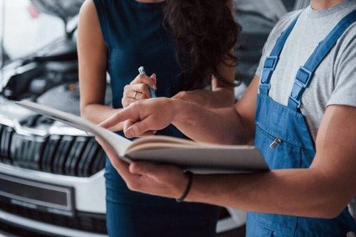 your signature please woman auto salon with employee blue uniform taking her repaired car back 14667.jpg