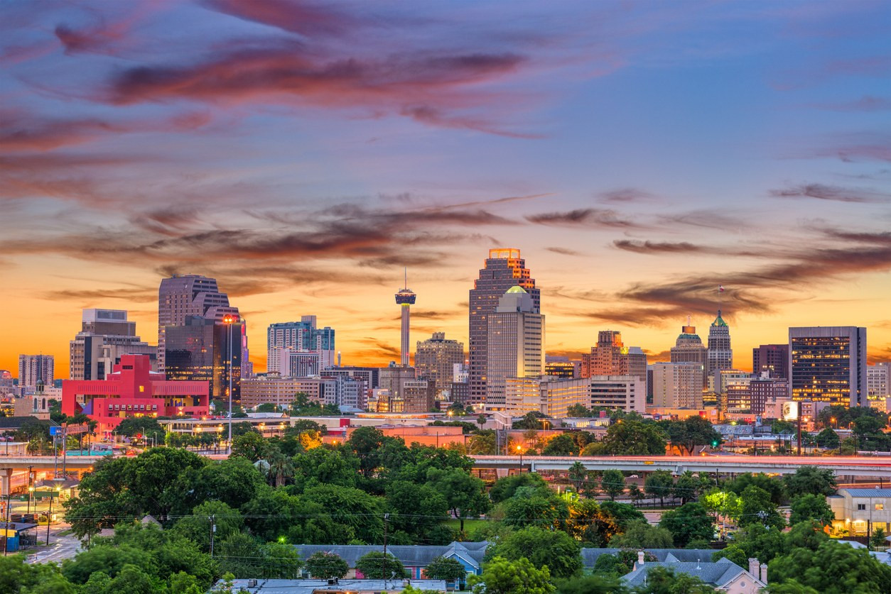 San Antonio skyline with homes and rental signs