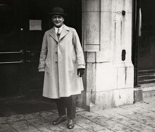Zanger Kees Pruis poseert in 1925 voor de ingang van De Kroon in Amsterdam.jpg