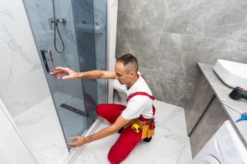 Workers are installing glass door of the shower enclosure. High quality photo.jpg