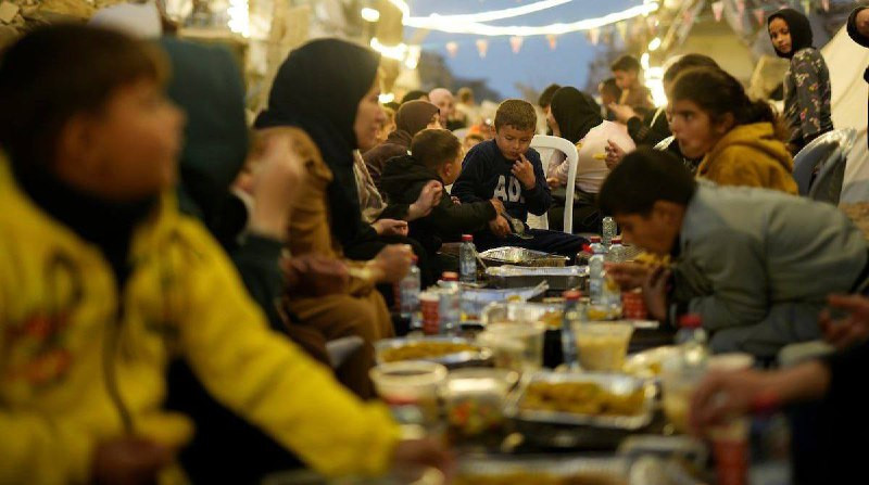 فلسطينيون يتناولون طعام الافطار خلال اليوم الخامس من شهر رمضان على انقاض المنازل المدمرة شمال قطاع غزة....