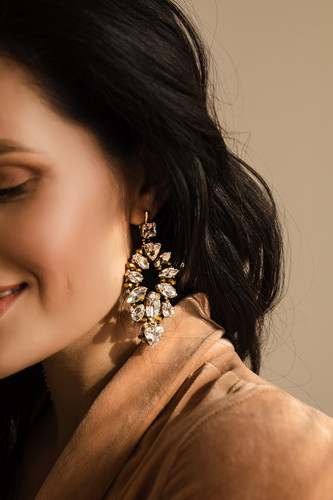 portrait young woman with earrings with gems isolated.jpg