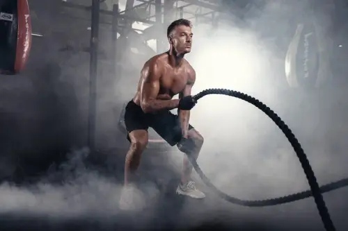 athletic man doing crossfit exercises with rope smoky gym 120960 2579.webp
