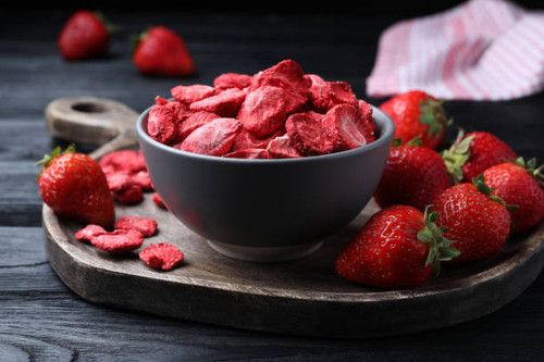 Freeze dried and fresh strawberries on black wooden table, closeup.jpg