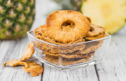 Pineapple rings (dried) on rustic wooden background as close-up shot.jpg