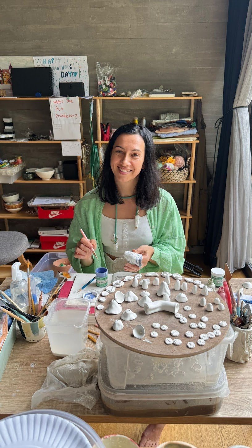 Painting tiny porcelain pendants at the worktable
