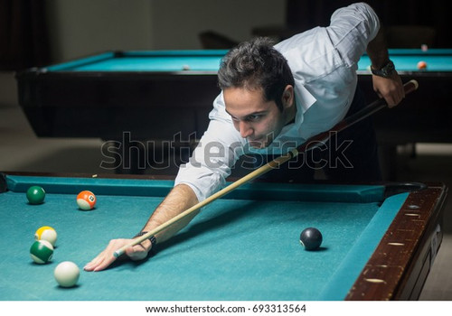 young man playing billiards bending 600w 693313564.jpg