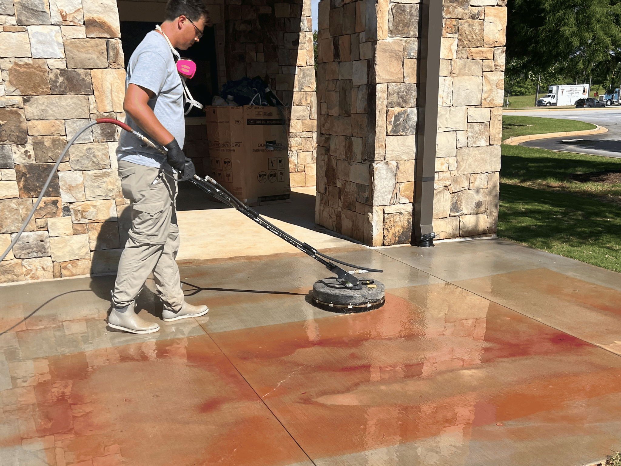 Professional concrete cleaning crew using commercial surface cleaner on driveway in North Georgia