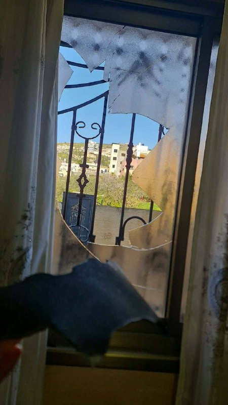 تضرر نوافذ أحد المنازل في بلدة حوارة، جنوب نابلس، نتيجة سقوط شظايا للصواريخ....