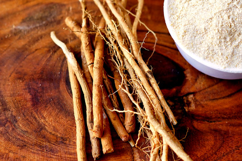 Ashwagandha Roots and powder known as Withania somnifera in white bowl on wooden background. Indian .jpg
