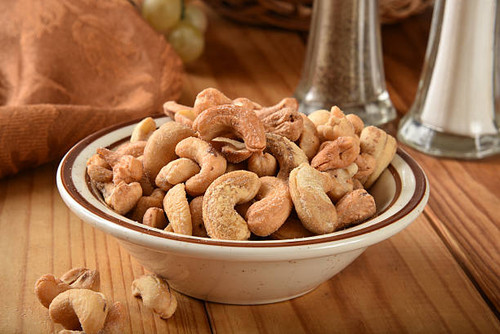 Closeup of a bowl of cashews on a rustic wooden table.jpg
